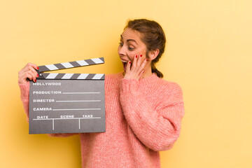 young pretty woman feeling happy, excited and surprised. cinema clapper concept