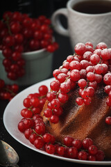 A cake with fresh red currant and tea	