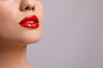 Fototapeta premium Closeup view of woman with beautiful full lips on grey background. Space for text