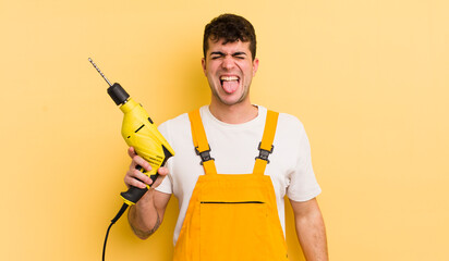 young handsome man with cheerful and rebellious attitude, joking and sticking tongue out. handyman...