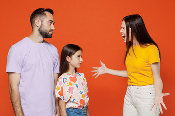Young angry parents mom dad with child kid daughter teen girl in basic t-shirts scold spread hands scream shout isolated on yellow background studio portrait. Family day parenthood childhood concept