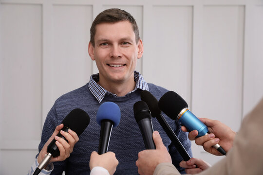 Happy business man giving interview to journalists at official event