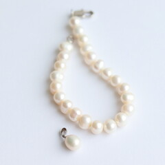 Pearl bracelet and pendant isolated on white background. 