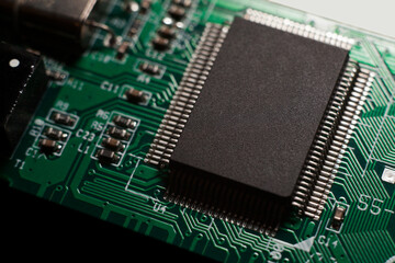 Macro photo of a green computer printed circuit board with selective focus on an blank chip.