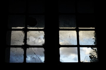 Clouds in the sky over the broken window in an abandoned building