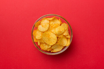 Potato chips on bowl isolated on colored background. Delicious crispy potato chips in bowl. Space for text. Top view
