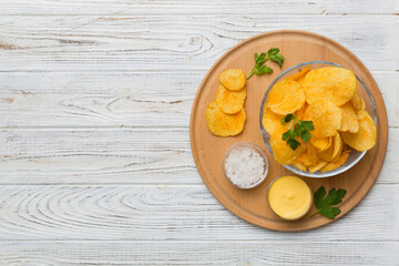 Top view chips with sause in bowl on colored background, top view with copy space