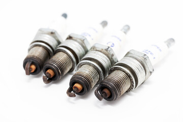 Used spark plugs of a crossover gasoline engine on a white background
