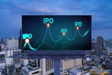 IPO icon hologram on road billboard over night panorama city view of Bangkok. The hub of initial...