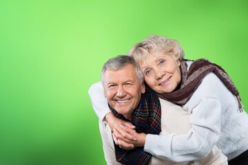 Senior man carrying his wife on his shoulders laughing. Attractive crazy old senior couple