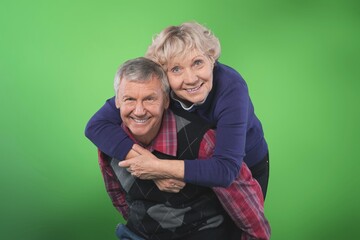 Senior man carrying his wife on his shoulders laughing. Attractive crazy old senior couple