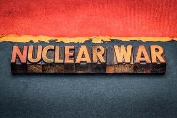 nuclear war - words in vintage letterpress wood type against abstract gloomy, black, orange and red paper landscape