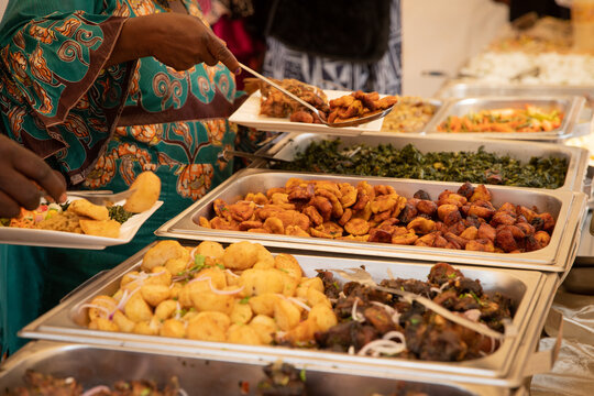 Close-up of African food during a buffet at a party. Fried plantains, potatoes, meat and vegetables