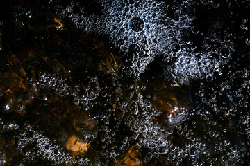 Foam on the water. Dark water.