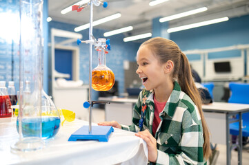 Girl sideways to camera looking at flask