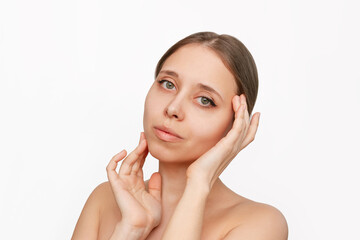 Portrait of a young beautiful caucasian woman with makeup touching the skin of her face isolated on a white background. Beauty and fashion. Skin care