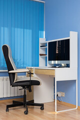 a fragment of the room where there is a computer desk and an armchair
