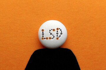 LSD tablet on an orange background in the form of a silhouette of a man with an inscription of...
