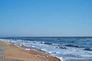 Image of sea foam on a sandy beach.