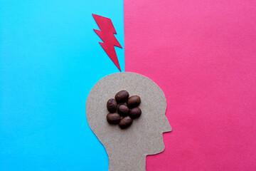 Caffeine overdose. A caffeinated blow to the head. The head of a man with coffee beans inside. The image is made of cardboard.
