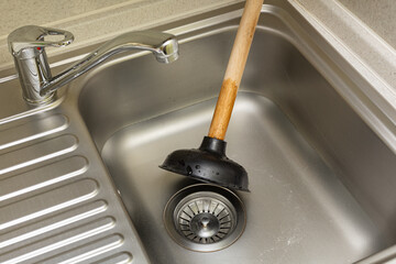 Vantus with a wooden handle lies in the sink in the kitchen