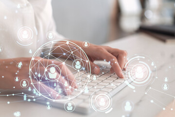 HR woman specialist is typing the keyboard in the internet to find the best candidates to create international network in recruitment process. Formal wear. Social media hologram icons.