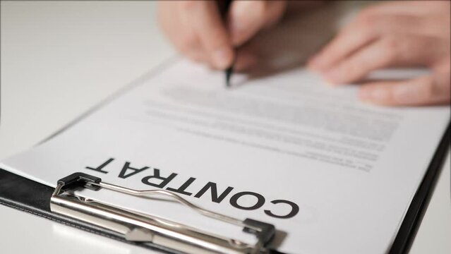 Contract in French. The hands of man or woman sign paper copy of the agreement. Universal form of contract in France.