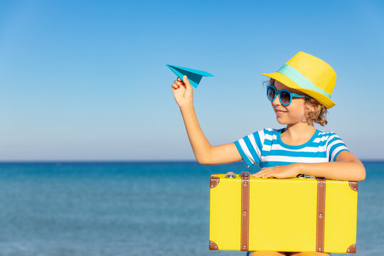 Child with vintage suitcase on summer vacation
