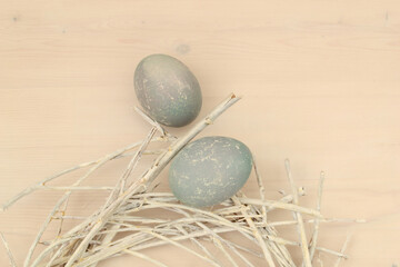 Easter eggs with a beautiful eco-friendly pattern lying in a decorative nest of white rods