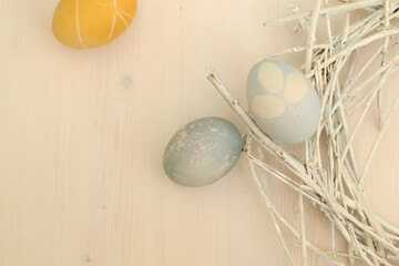 Easter eggs with a beautiful eco-friendly pattern lying in a decorative nest of white rods