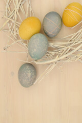 Easter eggs with a beautiful eco-friendly pattern lying in a decorative nest of white rods