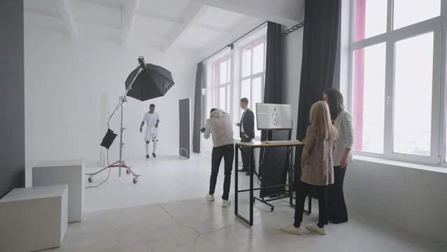 team is photographing afro-american football champion for magazine and ad campaign in studio