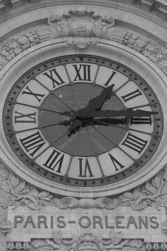 Exterior large clock face on building in black and white, Musee d'Orsay, Paris France