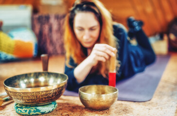 Spiritual girl immersed in meditative sounds of tibetian bowl.
