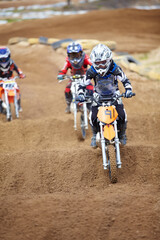 Fototapeta na wymiar Its a tricky part of the track. Three motocross riders riding in close proximity to each other.