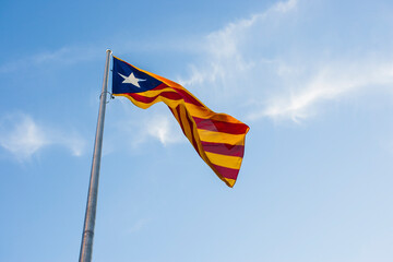 large flag of catalonia waving with iron mast
