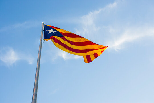 large flag of catalonia waving with iron mast