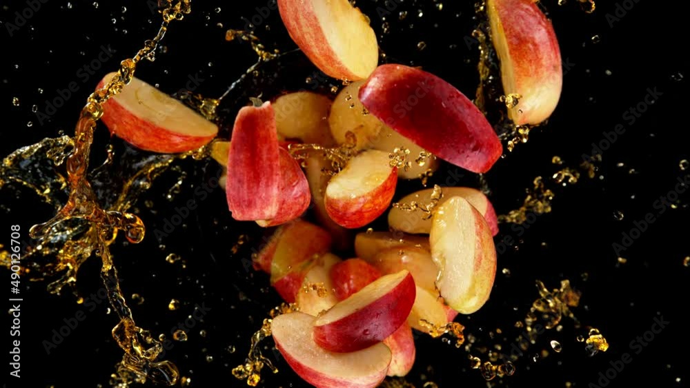 Aufkleber Super slow motion of rotating apples with splashing juice, black background. Filmed on high speed cinema camera, 1000 fps. Speed ramp effect.