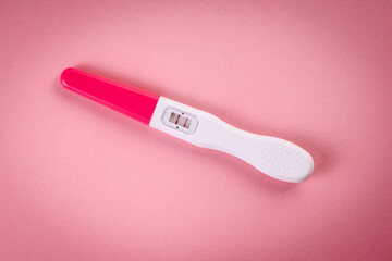 Positive pregnancy test on a pink background. New life concept