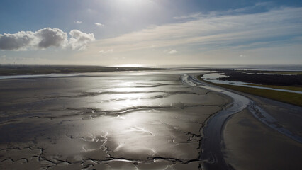 Luftaufnahmen von dem norddeutschen Wattenmeer an der Eider, Nordsee. Im Schlick und Watt sind bei Ebbe einzelne Priele sowie Watt-Vögel zu sehen.