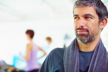 Smart thoughtful man. Closeup of smart thoughtful man in a gym looking away with people in background.