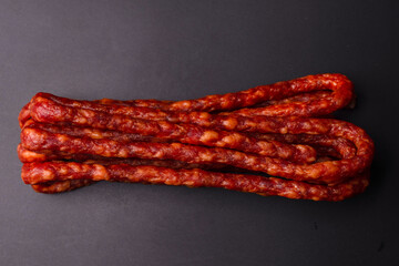 Cabanossi, dry sausage isolated on black background.