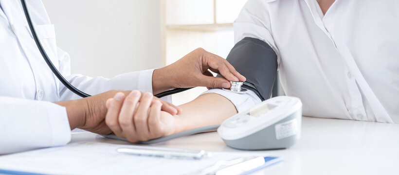 Doctor using a measuring blood pressure checking patient with examining, presenting results symptom and recommend treatment method, Healthcare and medical concept