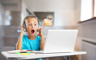 Serious focused preschooler learning online through video chat on a laptop. Child studying computer...