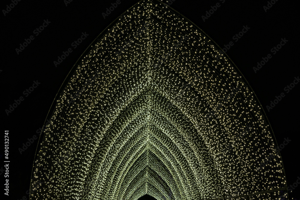 Poster yellow outdoor light tunnel made of many little light bulbs at night