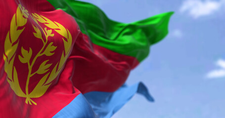 Detail of the national flag of Eritrea waving in the wind on a clear day