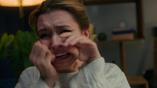 Crying woman close-up, portrait of scared female person in living room, feeling anger and stress, bad mood. Family problems, aggressive emotional wife having fear and fright. 