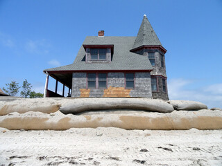 Scenic view of an old black gothic house on a sandy beach against the blue sky