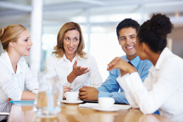 Female leader discussing with colleagues. Portrait of mature female leader with colleagues at...