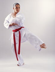 Shes got a solid kick. Shot of a young woman doing karate. © Mapodile M/peopleimages.com